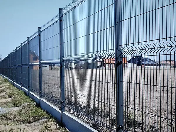 Tall profiled mesh panels along an industrial yard perimeter