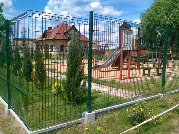 Welded mesh fence enclosing a residential garden and play area