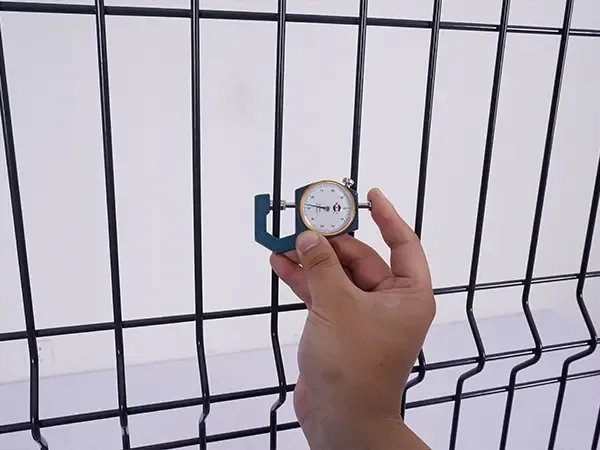 Wire diameter being checked on a black welded mesh panel